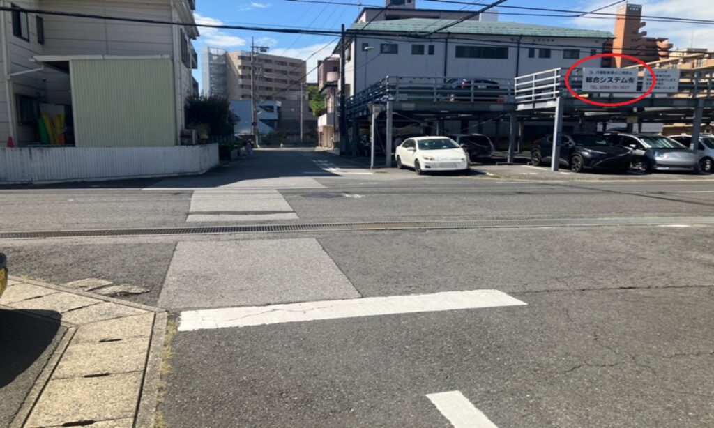 右手に「総合システム（有）」駐車場が見えてきます。この駐車場の 36番が当店の無料駐車場 です。