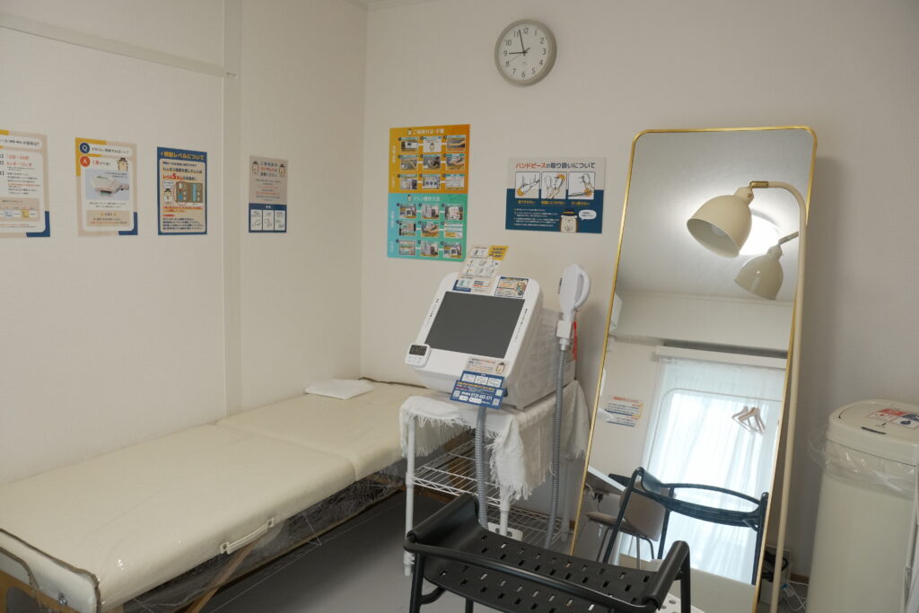 清潔で明るい施術スペース。説明ポスター付きで初めてでも使いやすい環境です。